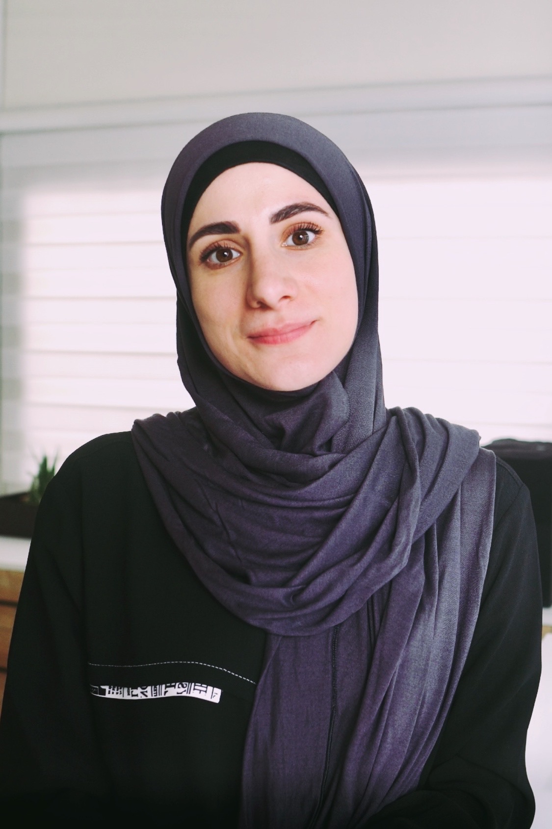 Portrait photo of Sara. On her shoulder sits a hand-drawn bird.